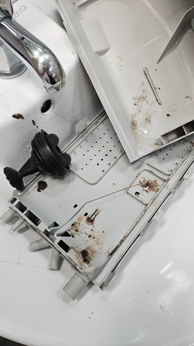 수원 드럼세탁기 청소 작업 전, 갈색 덩어리가 엉겨붙은 세제함 부품과 배수 거름망