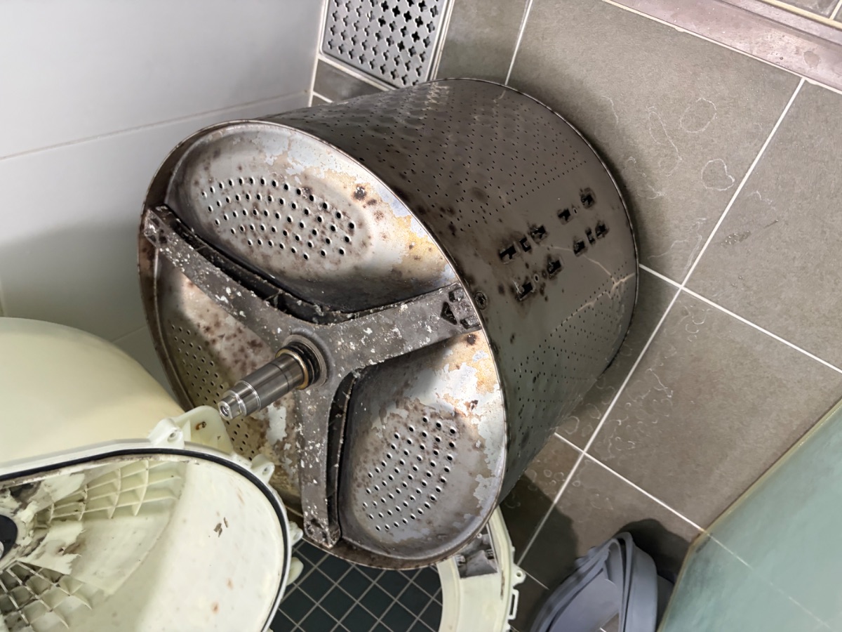 안양 드럼세탁기청소 작업 전, 꺼낸 속통 바깥면이 전체적으로 변색되고 날개를 뗀 자리가 검은 모습